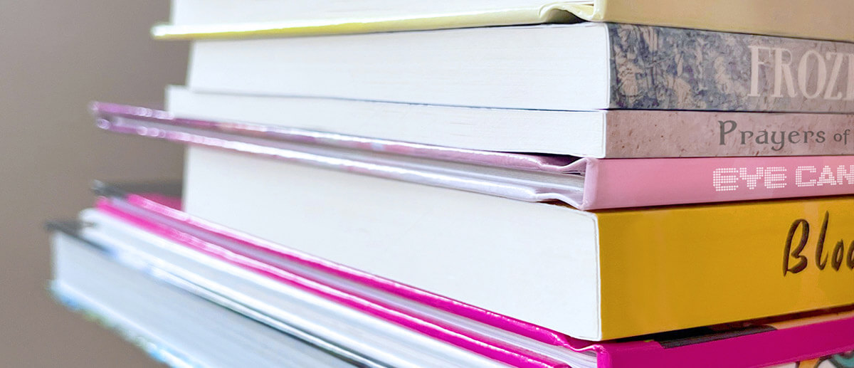 Stack of professionally printed custom books showcasing high-quality covers and binding by OnPress.