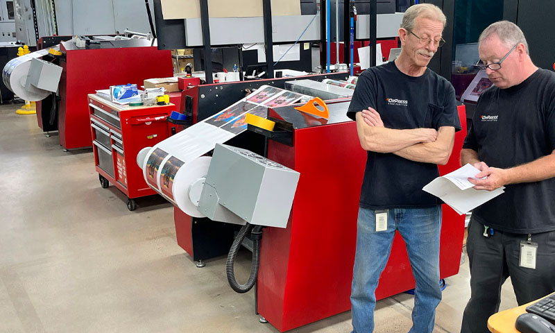 Professional prepress technicians reviewing print proofs at OnPress facility